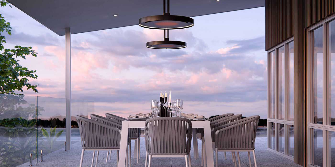 Two Bromic Eclipse electric patio heaters hanging above a large outdoor table in an semi-enclosed patio space.
