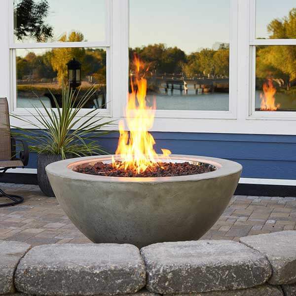 A small gas fire bowl on a patio with serene water view, ideal for relaxing evenings